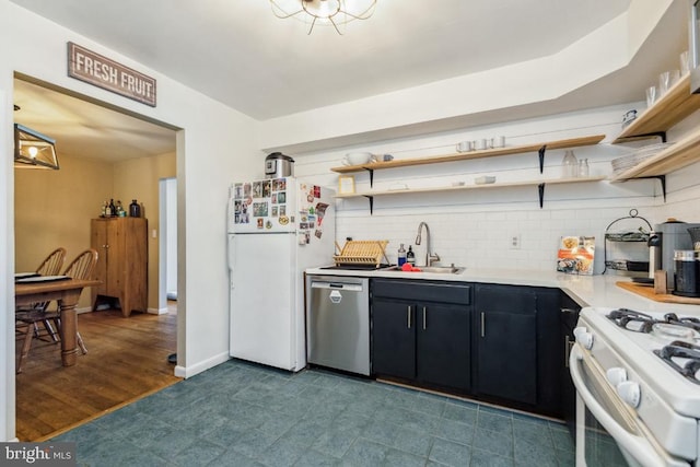  - kitchen with white appliances, a sink, open shelves, dark cabinets, and light countertops
