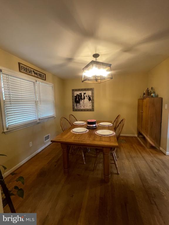 dining area with wood finished floors, baseboards, and a chandelier