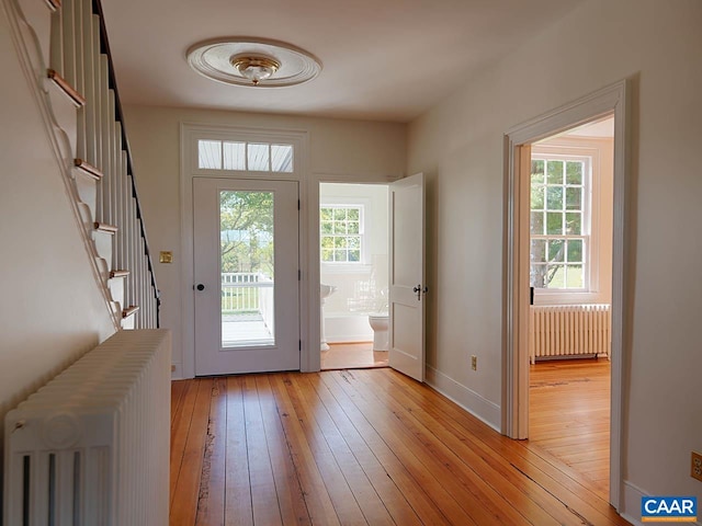 entryway with radiator heating unit and light wood-type flooring