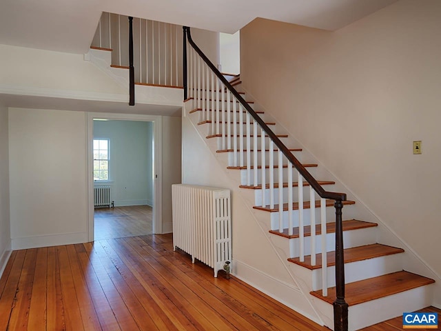 staircase featuring wood-type flooring and radiator heating unit