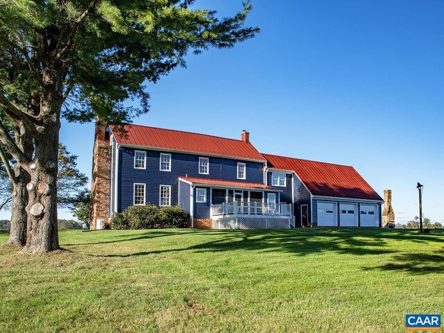 view of front of property featuring a garage, covered porch, and a front lawn