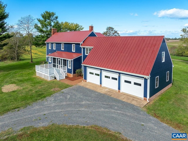 view of front of home with a garage, an outdoor structure, and a front lawn