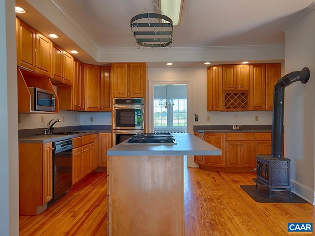 kitchen featuring a center island, appliances with stainless steel finishes, sink, and ornamental molding