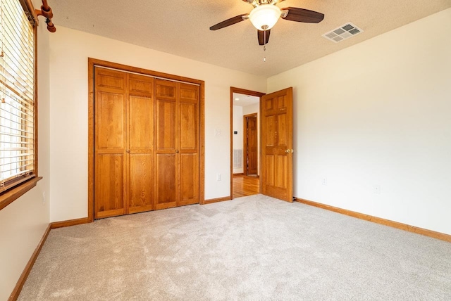 17962 Old Barn Ln, Elkton, VA 22827 - unfurnished bedroom with light carpet, a closet, a textured ceiling, and a ceiling fan
