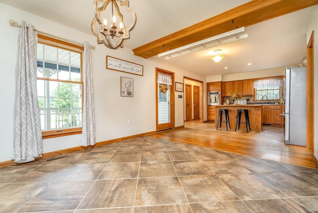 17962 Old Barn Ln, Elkton, VA 22827 - kitchen with appliances with stainless steel finishes, brown cabinets, beam ceiling, a breakfast bar area, and a chandelier
