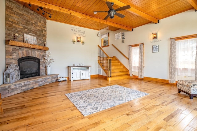 17962 Old Barn Ln, Elkton, VA 22827 - living room featuring a wood ceiling with exposed beams, stairway, a ceiling fan, hardwood / wood-style flooring, and a stone fireplace