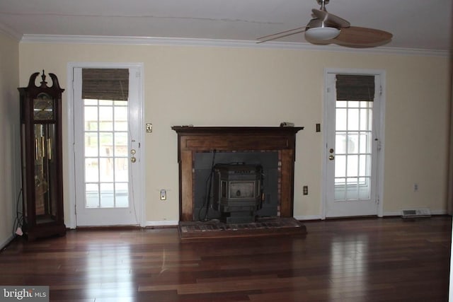  - unfurnished living room with a wood stove, a ceiling fan, crown molding, wood finished floors, and baseboards