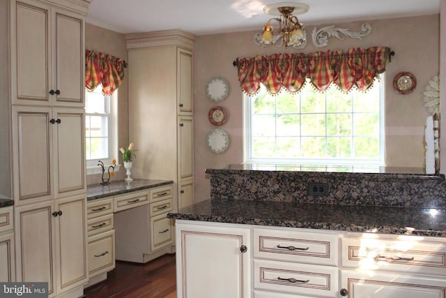  - kitchen with cream cabinetry, dark wood finished floors, and dark stone counters