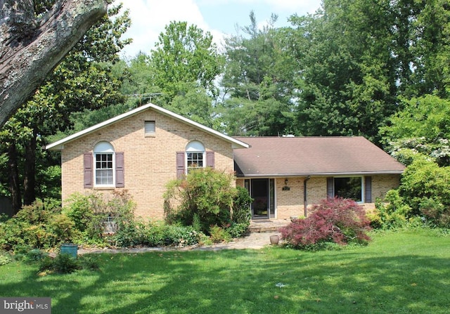  - view of front facade with brick siding and a front lawn