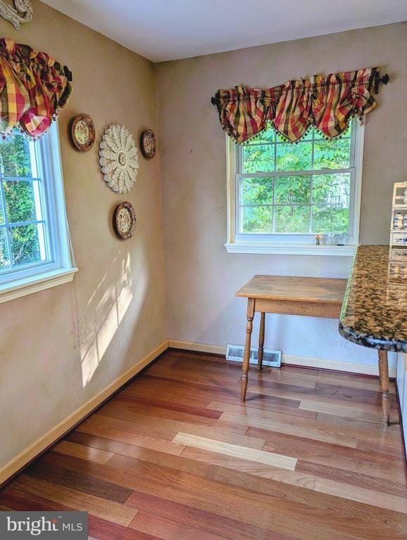  - unfurnished dining area featuring wood finished floors and baseboards