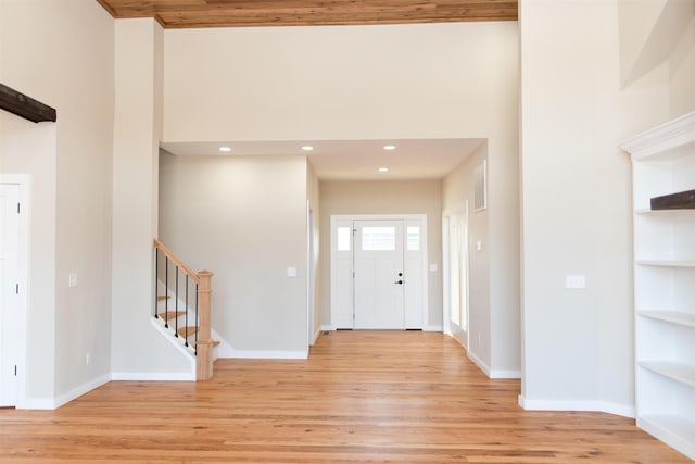 entryway featuring a towering ceiling and light hardwood / wood-style floors