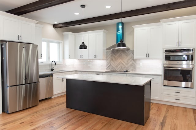 kitchen with stainless steel appliances, decorative light fixtures, white cabinets, and wall chimney exhaust hood