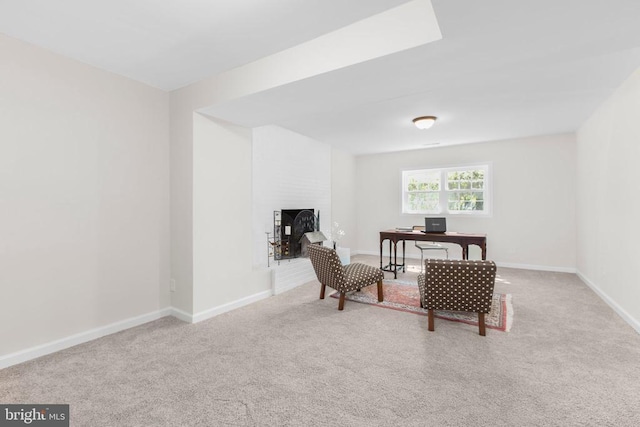 carpeted office space with a brick fireplace and baseboards
