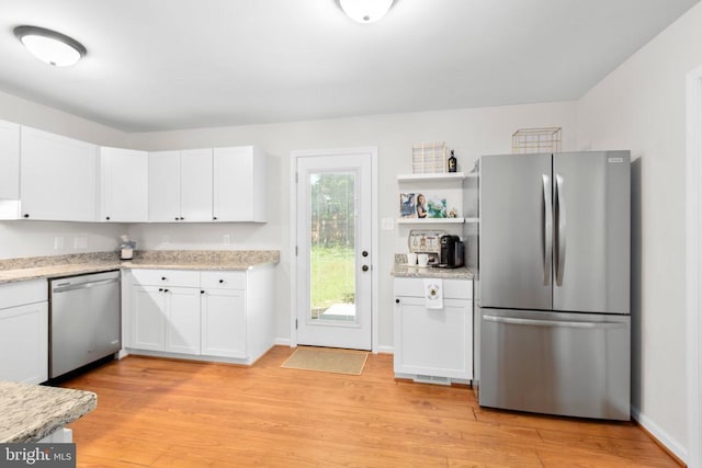 kitchen with stainless steel appliances, light wood-style floors, white cabinetry, and open shelves