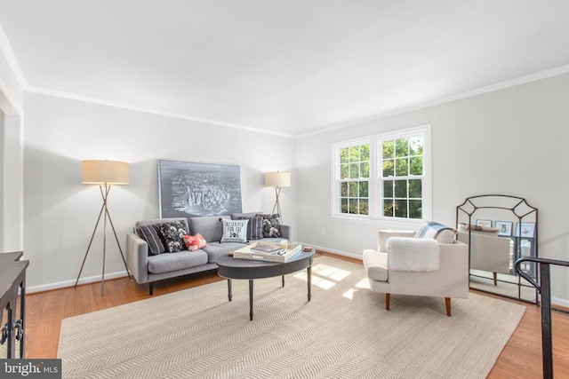 living room featuring wood finished floors, crown molding, and baseboards