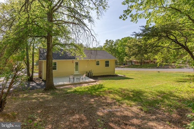 rear view of house featuring a patio area, a lawn, and cooling unit