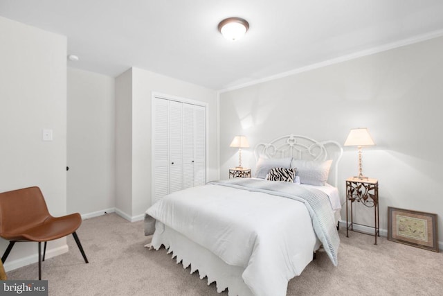 carpeted bedroom featuring a closet and baseboards