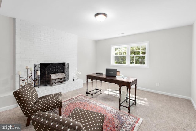carpeted office featuring baseboards and a brick fireplace