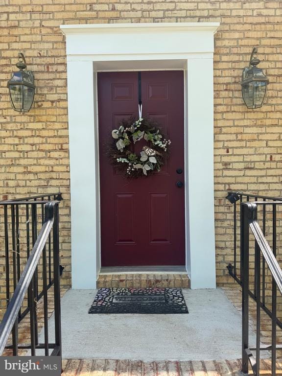view of exterior entry featuring brick siding