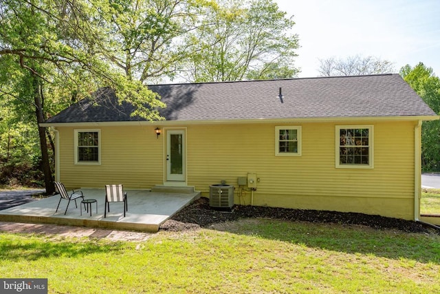 rear view of house featuring central air condition unit, a yard, and a patio area