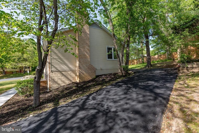 view of side of home with fence and a chimney