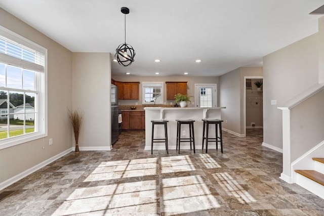 43 Upland Ct, Stuarts Draft, VA 24477 - kitchen featuring brown cabinetry, a breakfast bar area, stone finish flooring, a chandelier, and recessed lighting