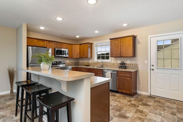 43 Upland Ct, Stuarts Draft, VA 24477 - kitchen featuring appliances with stainless steel finishes, light countertops, brown cabinets, a kitchen bar, and recessed lighting
