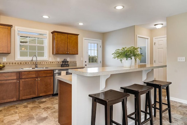 43 Upland Ct, Stuarts Draft, VA 24477 - kitchen with stainless steel dishwasher, a kitchen bar, brown cabinets, light countertops, and a kitchen island