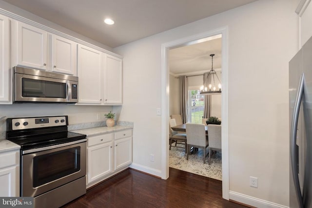 kitchen featuring appliances with stainless steel finishes, baseboards, dark wood-style flooring, a chandelier, and white cabinets