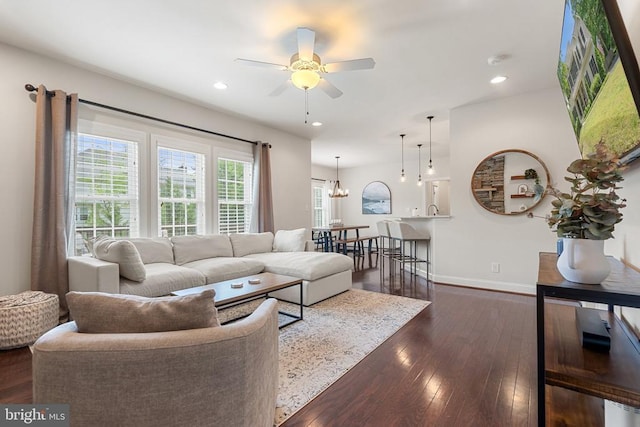 living room with dark wood finished floors, ceiling fan, baseboards, recessed lighting, and a chandelier