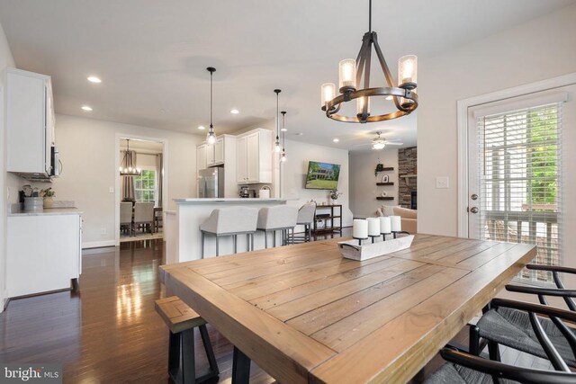 dining area with a chandelier, ceiling fan, dark wood-style flooring, recessed lighting, and baseboards