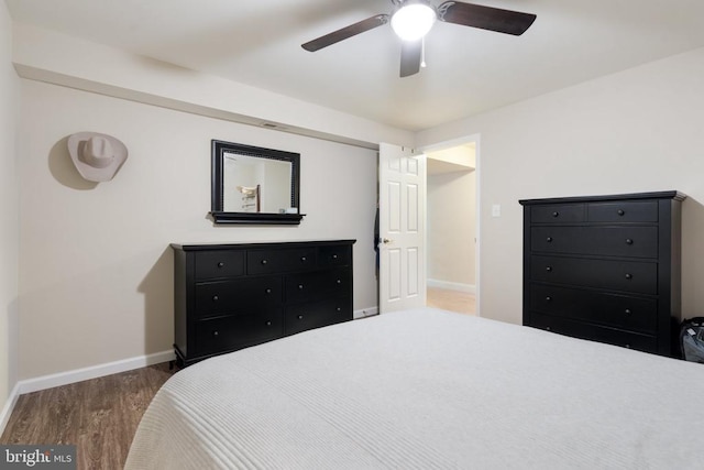 bedroom featuring baseboards, wood finished floors, and a ceiling fan