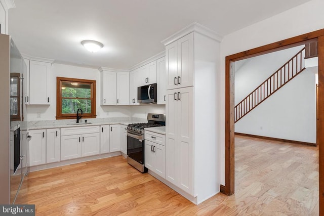 15395 Rillhurst Dr, Culpeper, VA 22701 - kitchen with appliances with stainless steel finishes, a sink, light wood-style floors, and white cabinets