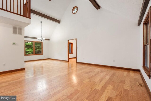 15395 Rillhurst Dr, Culpeper, VA 22701 - unfurnished living room with a chandelier, beam ceiling, high vaulted ceiling, light wood finished floors, and baseboards