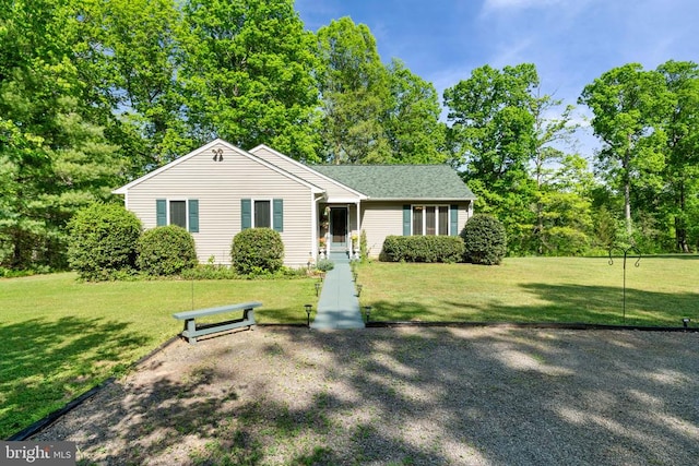 view of front of house with a front yard and view of scattered trees