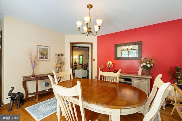 dining area with a chandelier and wood finished floors