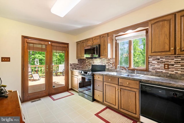 kitchen featuring stainless steel appliances, a sink, french doors, and backsplash