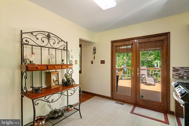 doorway with french doors and baseboards