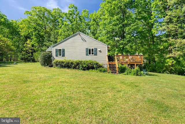 view of side of property featuring a wooden deck, stairway, and a yard