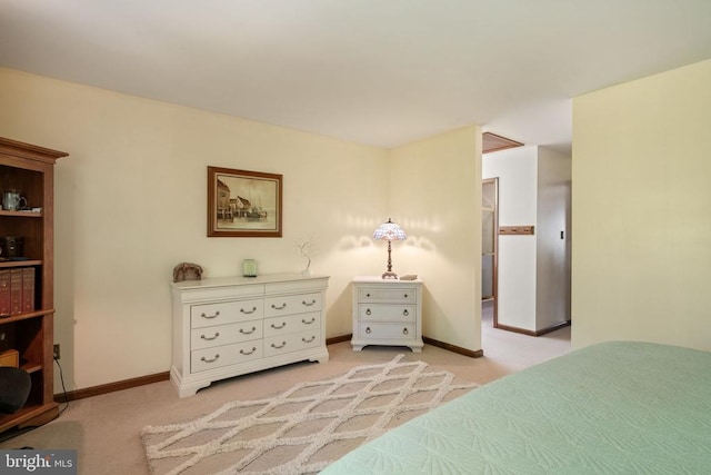 bedroom featuring light colored carpet and baseboards