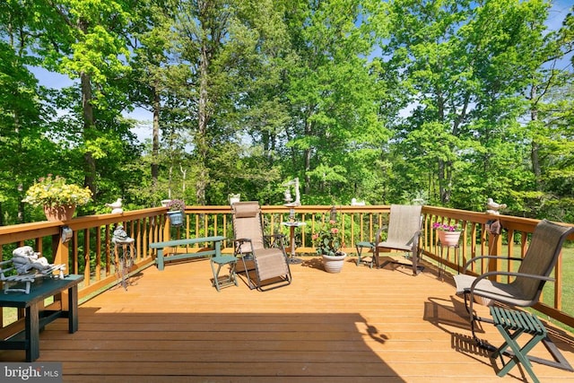 wooden deck with view of wooded area