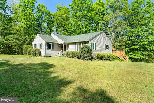ranch-style home with a front yard and a shingled roof