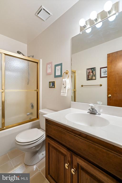 bathroom featuring vanity, toilet, and combined bath / shower with glass door