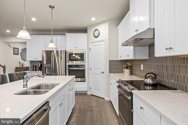 11326 Oakville Ln, Spotsylvania, VA 22551 - kitchen with stainless steel appliances, backsplash, a breakfast bar, a center island with sink, and wood finished floors