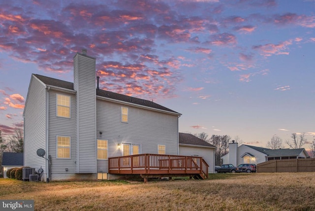 10501 Crestfield Ln, Spotsylvania, VA 22553 - back of house at dusk featuring a chimney, a deck, and central AC