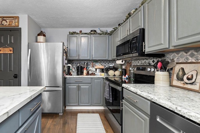 1294 Victorian Village Dr, Harrisonburg, VA 22802 - kitchen featuring stainless steel appliances, tasteful backsplash, gray cabinets, a textured ceiling, and dark wood finished floors