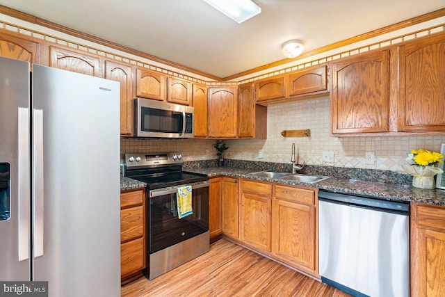 4117 Dartmoor Ct, Fredericksburg, VA 22408 - kitchen featuring appliances with stainless steel finishes, a sink, tasteful backsplash, light wood-type flooring, and dark stone countertops