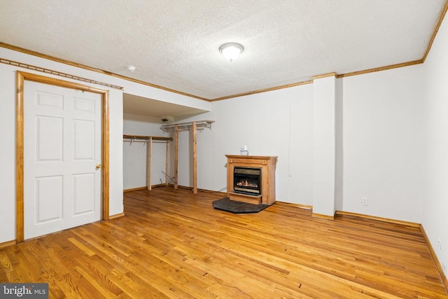 4117 Dartmoor Ct, Fredericksburg, VA 22408 - unfurnished living room with crown molding, a textured ceiling, light wood-style flooring, a lit fireplace, and baseboards
