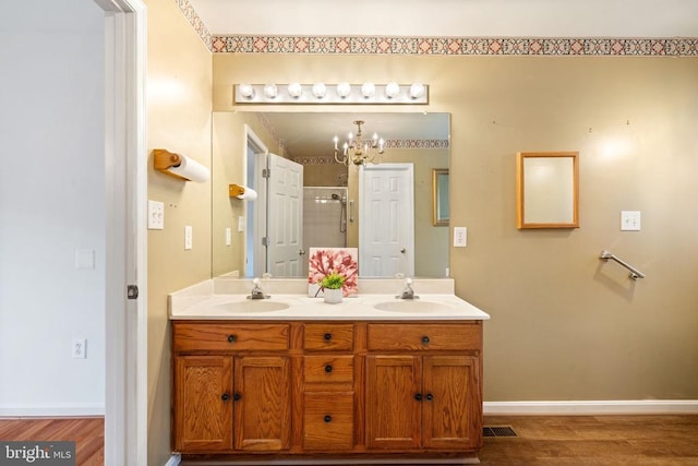 4117 Dartmoor Ct, Fredericksburg, VA 22408 - full bath with a chandelier, double vanity, a shower with door, wood finished floors, and baseboards