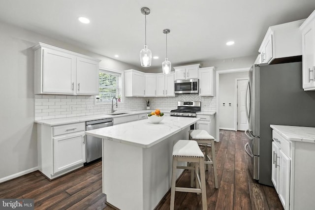 6205 Patrician Ct, Fredericksburg, VA 22407 - kitchen with stainless steel appliances, a center island, dark wood-style floors, backsplash, and white cabinetry